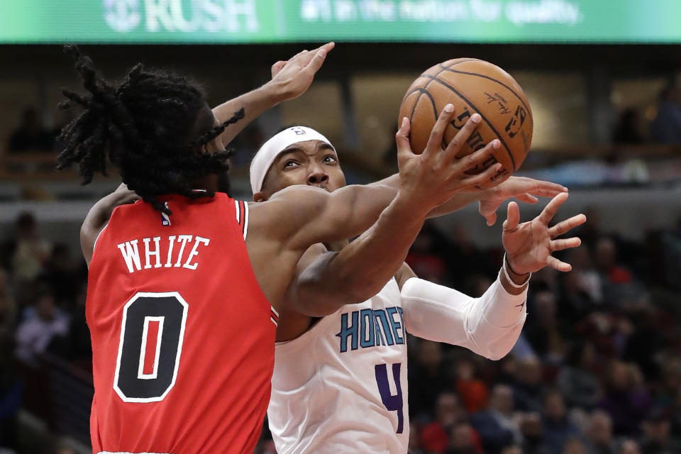 Charlotte Hornets guard Devonte' Graham, right, drives to the basket against Chicago Bulls guard Coby White during the first half of an NBA basketball game in Chicago, Thursday, Feb. 20, 2020. (AP Photo/Nam Y. Huh)