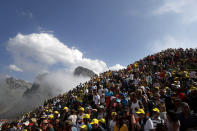 Spectators stand on the Tourmalet pass next to the finish line of the fourteenth stage of the Tour de France cycling race over 117.5 kilometers (73 miles) with start in Tarbes and finish at the Tourmalet pass, France, Saturday, July 20, 2019. (AP Photo/ Christophe Ena)