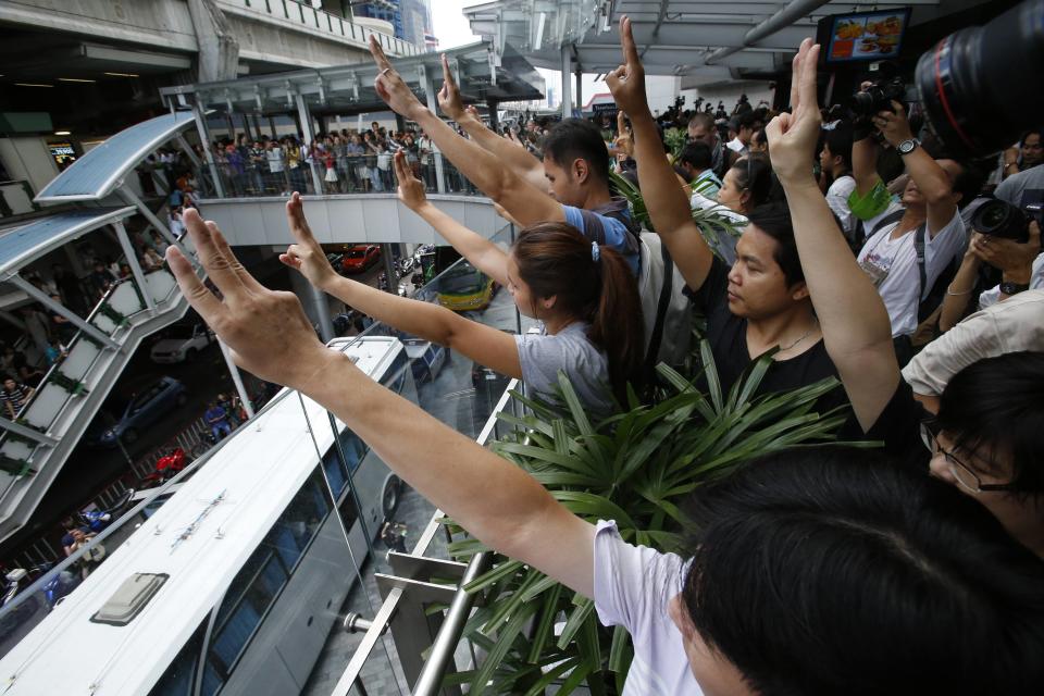 Protesters against military rule gesture by holding up their three middle fingers in the air, during a brief demonstration at a shopping mall in Bangkok June 1, 2014. Thailand's military government sent thousands of troops and police into central Bangkok on Sunday to stop any demonstrations against its seizure of power, and some shopping malls and train stations closed to avoid trouble. According to some, the three fingered gesture stood for freedom, equality and brotherhood. REUTERS/Erik De Castro (THAILAND - Tags: POLITICS CIVIL UNREST TPX IMAGES OF THE DAY)