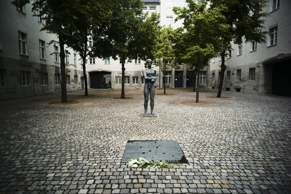 In this Friday, July 12, 2019 photo a sculpture and a remembrance plaque placed in the courtyard of the Bendlerblock building of the German defensive ministry where the German Resistance Memorial Center is located, in Berlin. Several leaders of the failed assassinate to Adolf Hitler on July 20, 1944 was shoot dead in the courtyard. The inscription reads: 'You did not bear the shame, you defend yourself, you gave the big eternal watch, a sign of repentance, your sacrificing your hot life for freedom right and honor'. (AP Photo/Markus Schreiber)