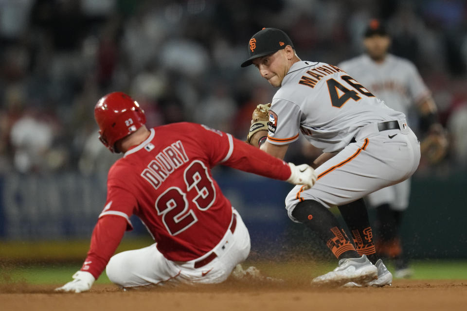 Los Angeles Angels' Brandon Drury (23) doubles ahead of a tag by San Francisco Giants second baseman Mark Mathias (46) during the seventh inning of a baseball game in Anaheim, Calif., Tuesday, Aug. 8, 2023. (AP Photo/Ashley Landis)