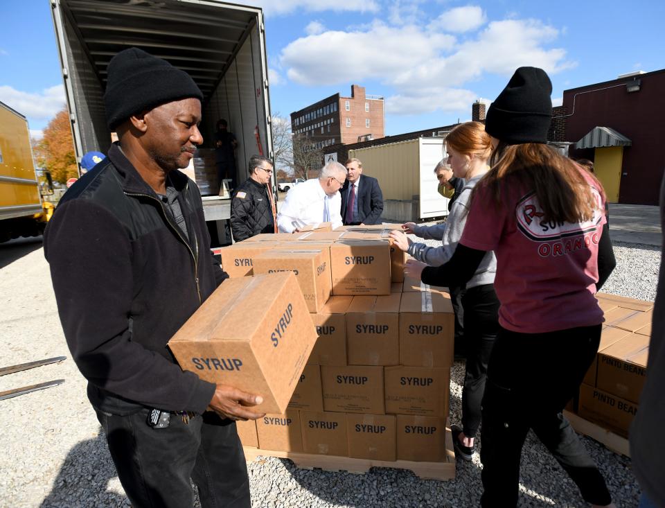 Pastor Raymont Johnson of Spirit of Faith Christian Center of Ohio, left, collects food donations Friday for their outreach program Family Empowerment Ministries Inc. in Alliance. The food donation was arranged by the University of Wyoming "Black 14" and the Church of Jesus Christ of Latter-day Saints.