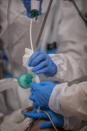 A medical team of the new Nurse Isabel Zendal Hospital perform a fiberoptic bronchoscopy to a patient of the COVID-19 ICU ward in Madrid, Spain, Monday, Jan. 18, 2021. As the coronavirus curve of contagion turned increasingly vertical after Christmas and New Year's, the Zendal has been busy. On Monday, 392 virus patients were being treated, more than in any other hospital in the Madrid region. (AP Photo/Bernat Armangue)