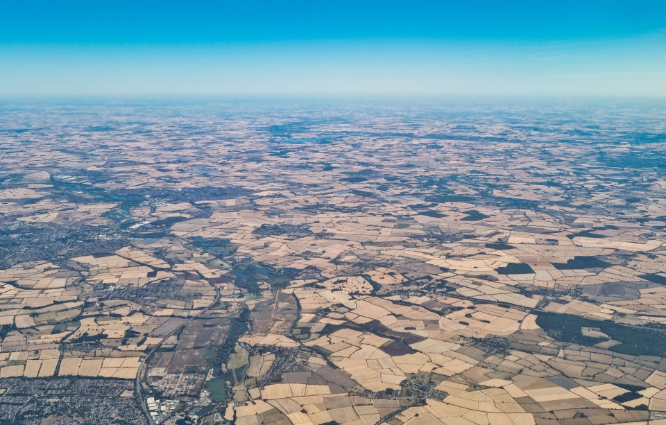 An aeriel view of part of the UK from a plane shows brown fields caused by the continued heatwave.(SWNS)