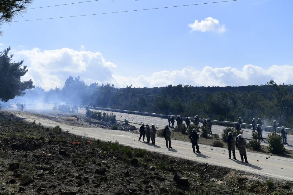 Riot police block a road during clashes in Karava near the area where the government plans to build a new migrant detention center, on the northeastern Aegean island of Lesbos, Greece, Wednesday, Feb. 26, 2020. Local authorities declared a 24-hour strike on two eastern Greek islands Wednesday to protest government plans to build new migrant detention camps there. (AP Photo/Michael Varaklas)