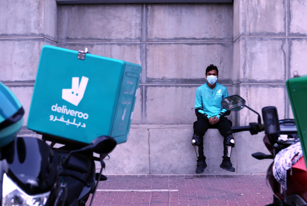 A food-delivery worker for Deliveroo takes a moment as he returns to work in Dubai, United Arab Emirates, May 2, 2022. Food-delivery drivers protesting wage cuts and grueling working conditions went on an extremely rare strike in Dubai on Saturday, April 30, 2022 — a mass walkout that paralyzed one of the country’s main delivery apps and revived concerns about labor conditions in the emirate. The strike ended early Monday, when London-based Deliveroo agreed to restore workers’ pay to $2.79 per delivery instead of the proposed rate of $2.38 amid surging fuel prices. (AP Photo/Isabel Debre)