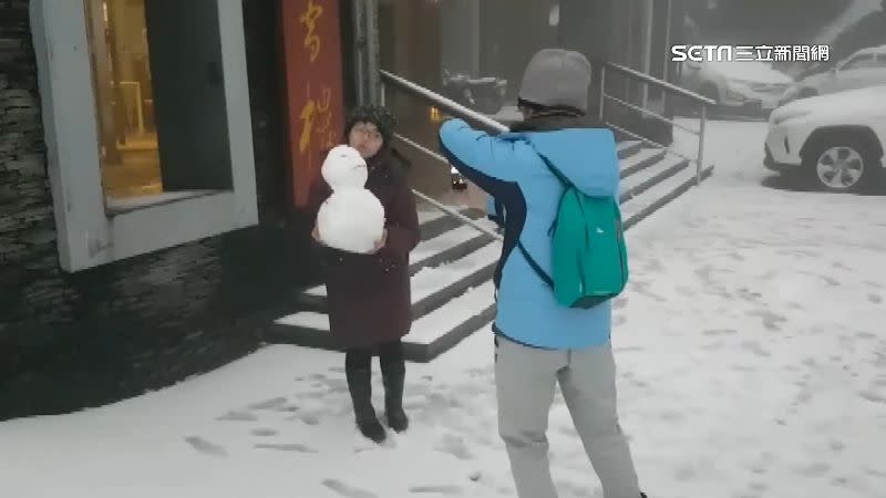 民眾見到降雪非常興奮，堆雪人拍照留念。