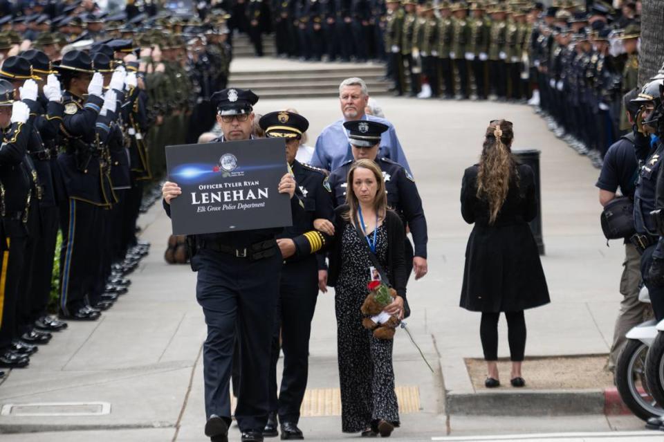 Jessica Lenehan, right, is escorted by Elk Grove police chief Bobby Davis on Monday during the California Peace Officers’ Memorial Ceremony at the state Capitol. Lenehan, who is a Sacramento Police officer, lost her husband Tyler Lenehan, an Elk Grove police officer who had also served in Galt and Citrus Heights, after a wrong way driver collided with him on Highway 99 in January 2022.