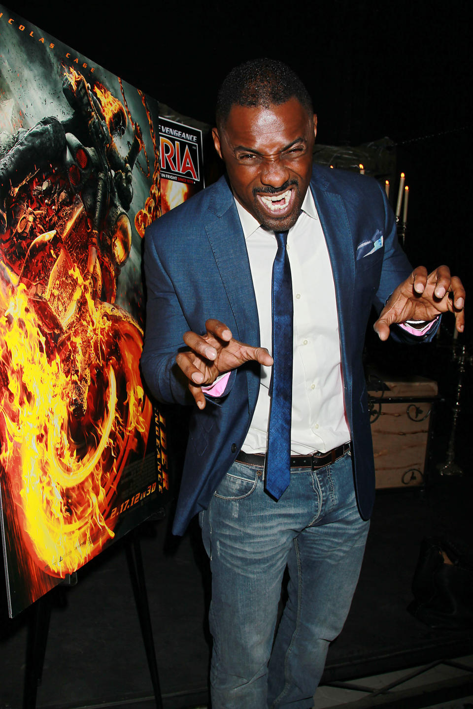 Idris Elba poses next to poster art from his latest film, "Ghost Rider Spirit of Vengeance," at a promotional event with fans at Times Scare in New York on Friday, Feb. 10, 2012. The film, also starring Nicolas Cage and Johnny Whitworth, opens on Feb. 17. (AP Photo/StarPix, Dave Allocca) -PICTURED: Nicolas Cage -PHOTO by: Dave Allocca/Starpix -FILENAME: DA5670255.JPG -LOCATION: Times Scare Startraks Photo New York, NY For licensing please call 212-414-9464 or email