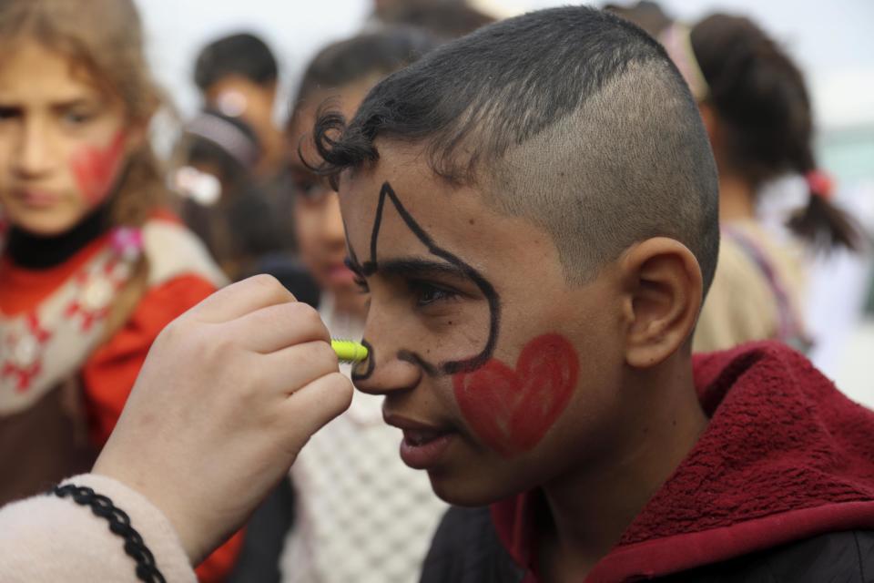 Iraqi internally displaced children having their faces painted during New Year's celebrations at the Hassan Sham camp, east of Mosul, Iraq, Saturday, Dec 31, 2016. (AP Photo/ Khalid Mohammed)