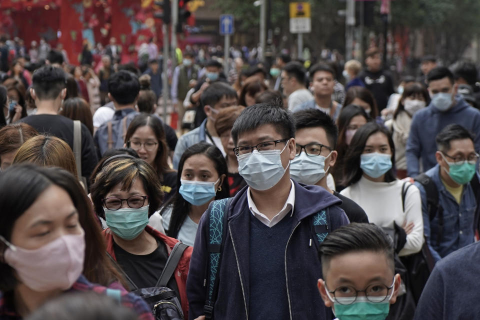 People wear masks on a street in Hong Kong, Friday, Jan. 24, 2020 to celebrate the Lunar New Year which marks the Year of the Rat in the Chinese zodiac. Cutting off access to entire cities with millions of residents to stop a new virus outbreak is a step few countries other than China would consider, but it is made possible by the ruling Communist Party's extensive social controls and experience fighting the 2002-03 outbreak of SARS. (AP Photo/Kin Cheung)
