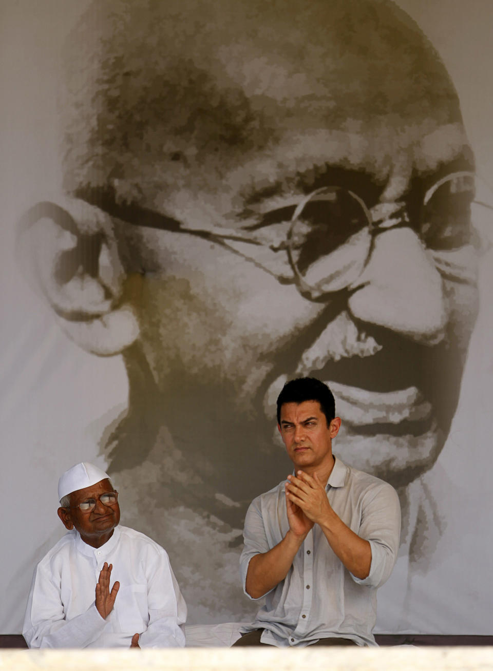 FILE-In this Aug. 27, 2011 file photo, Bollywood actor Aamir Khan, right, sits with India's anti-corruption activist Anna Hazare during the 12th day of Hazare's hunger strike against corruption in New Delhi, India. Bollywood megastar Khan is making India confront its dark side. Shining light on inequities like the rampant abortion of female fetuses, caste discrimination and the slaying of brides in dowry disputes, actor Khan has reached an estimated one-third of the country with a new TV talk show "Satyamev Jayate", or "Truth Alone Prevails," that tackles persistent flaws of modern India that most of its citizens would prefer to ignore.(AP Photo/Rajesh Kumar Singh, File)