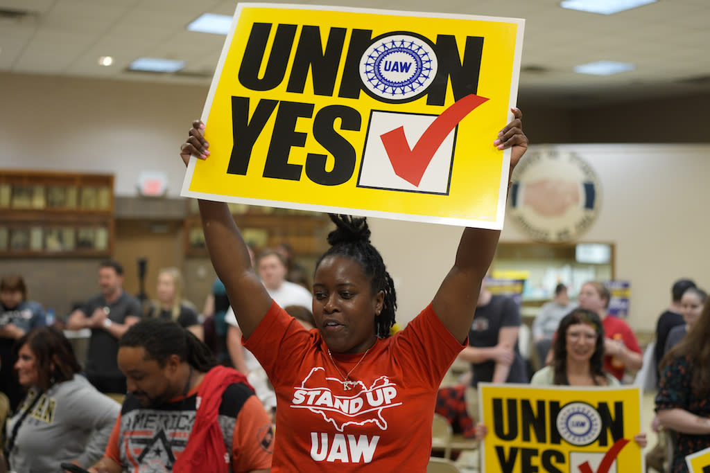 An auto plant worker holds up a pro-union sign.