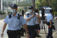 Police officers stand guard as they wait for Tong Ying-kit's arrival at a court in Hong Kong Tuesday, July 27, 2021. Hong Kong High Court will deliver verdict in the afternoon for the first person charged under Hong Kong's National Security Law. Tong was arrested in July 2020 after driving his motorbike into a group of police officers while carrying a flag bearing the protest slogan “Liberate Hong Kong." He was charged with inciting separatism and terrorism. (AP Photo/Vincent Yu)