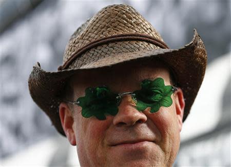 A racegoer poses for a photograph during the Cheltenham Festival horse racing meet in Gloucestershire, western England March 11, 2014. REUTERS/Eddie Keogh