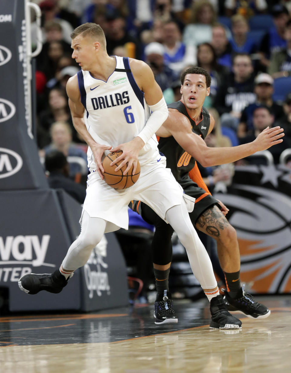 Dallas Mavericks forward Kristaps Porzingis (6) moves to the basket as he gets around Orlando Magic forward Aaron Gordon, right, during the second half of an NBA basketball game, Friday, Feb. 21, 2020, in Orlando, Fla. (AP Photo/John Raoux)