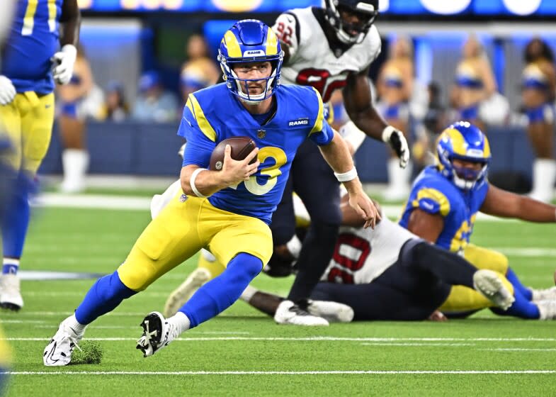 Rams quarterback John Wolford scrambles to pick up a first-quarter first down against the Texans on Aug. 18, 2022.
