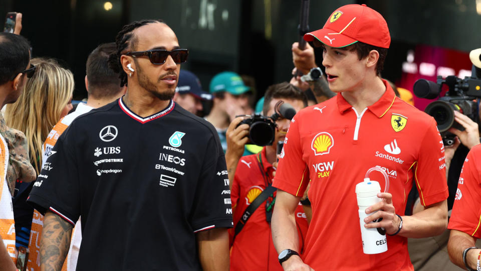 Seven-time Formula 1 champion Lewis Hamilton, age 39, walks with Ferrari's 19-year-old substitute driver, Oliver Bearman, prior to the 2024 Saudi Arabian Grand Prix.