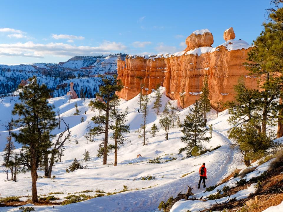 A hiker ventures along the snowy trails of Utah in the winter.