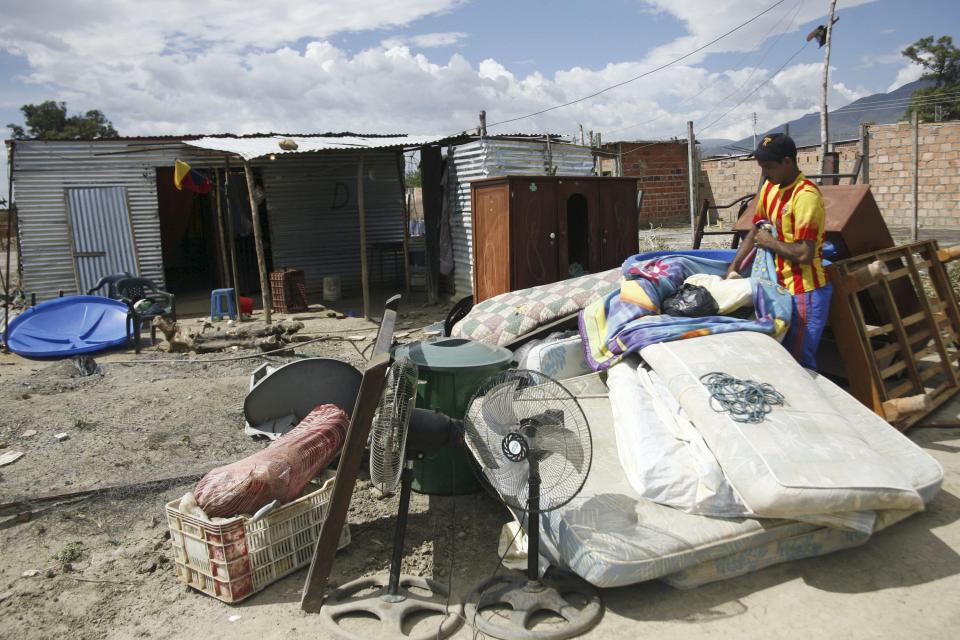 A man carries his belongings next to houses of people who do not possess proper documentation to live in Venezuela at San Antonio in Tachira state