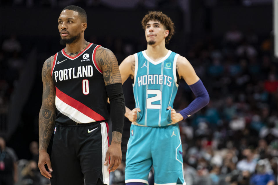 Portland Trail Blazers guard Damian Lillard (0) and Charlotte Hornets guard LaMelo Ball (2) look on during the first half of an NBA basketball game, Sunday, Oct. 31, 2021, in Charlotte, N.C. (AP Photo/Matt Kelley)