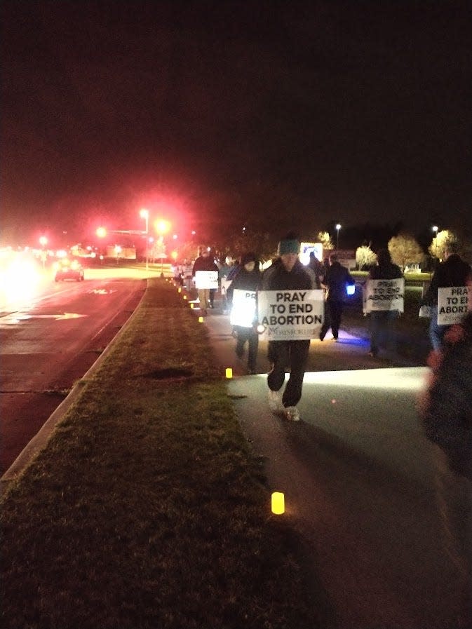 A group of people hold 40 Days for Life 'Pray to End Abortion' signs on a sidewalk near Planned Parenthood in fall 2022. The rally was part of a candlelight vigil, as seen on Taylor Drive in Sheboygan, Wis.