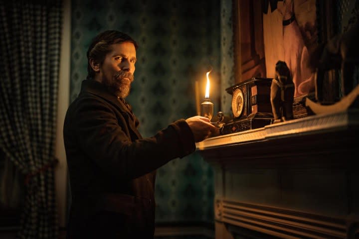 Christian Bale holds a candle in The Pale Blue Eye.