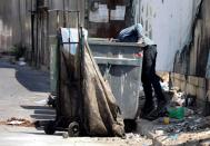 FILE PHOTO: A man searches through a garbage bin in Beirut