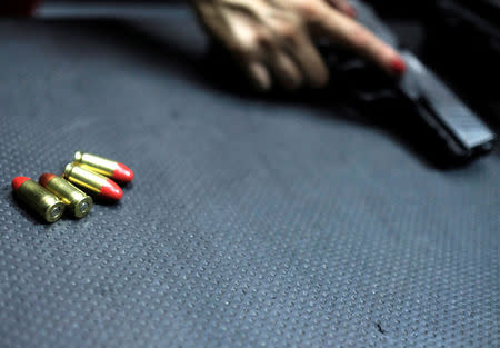 A woman prepares to fire a handgun at the 1911 Shooting Club in Sao Paulo, Brazil, January 11, 2019. Picture taken January 11, 2019. REUTERS/Nacho Doce