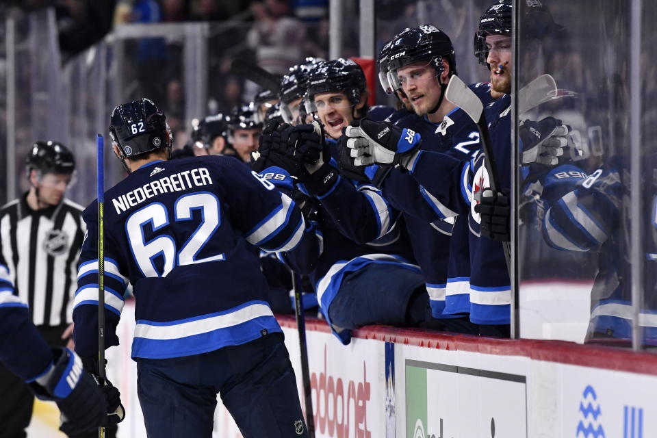 Winnipeg Jets' Nino Niederreiter (62) celebrates his goal against the San Jose Sharks with teammates on the bench during the second period of an NHL hockey game, in Winnipeg, Manitoba, on Monday March 6, 2023. (Fred Greenslade/The Canadian Press via AP)