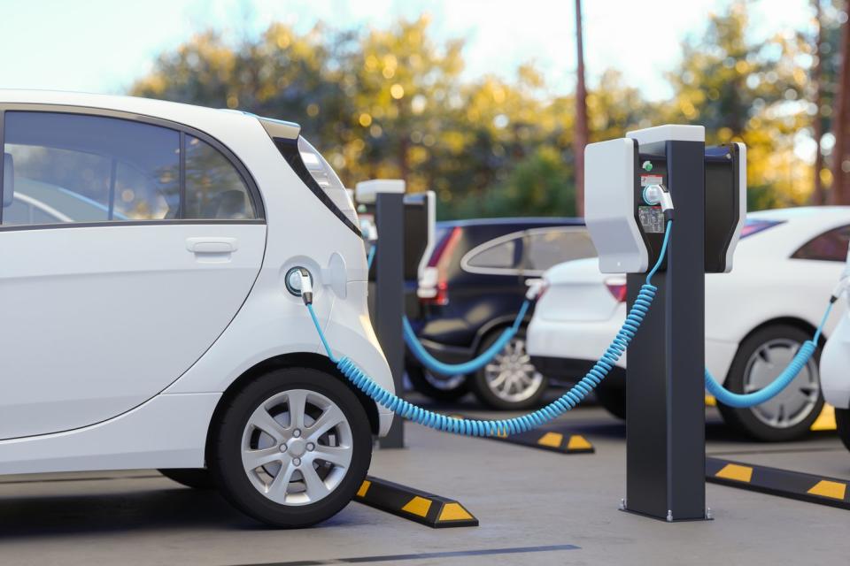 White EV charging at outdoor public charging station.