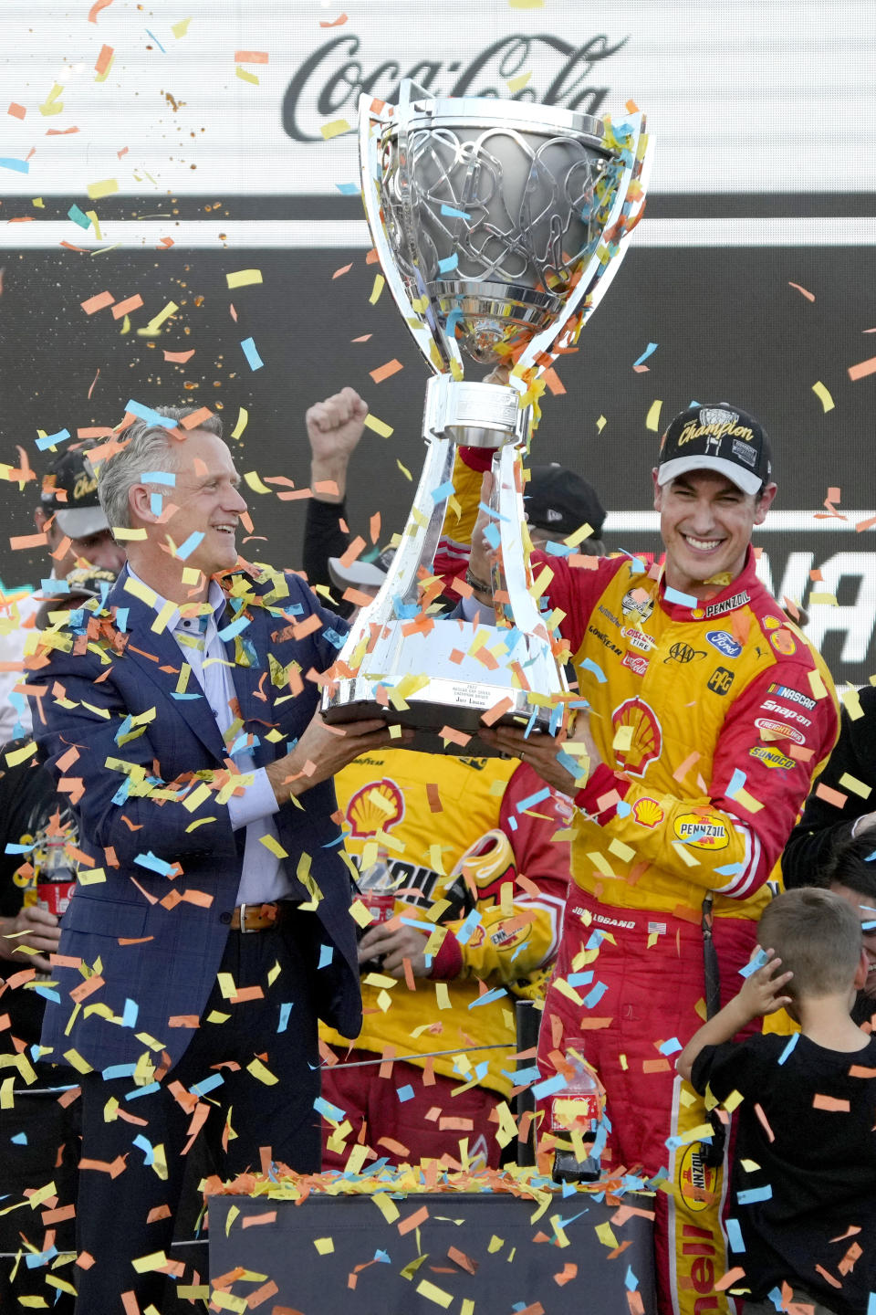 Joey Logano, right, and NASCAR President Steve Phelps hold up the championship trophy after winning a NASCAR Cup Series auto race and championship Sunday, Nov. 6, 2022, in Avondale, Ariz. (AP Photo/Rick Scuteri)