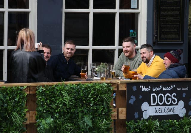 People enjoy a drink at a table outside a pub