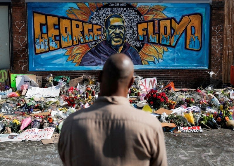 A local resident stands in front of a makeshift memorial honoring George Floyd, at the spot where he was taken into custody, in Minneapolis, Minnesota, U.S., June 1, 2020.  REUTERS/Carlos Barria    