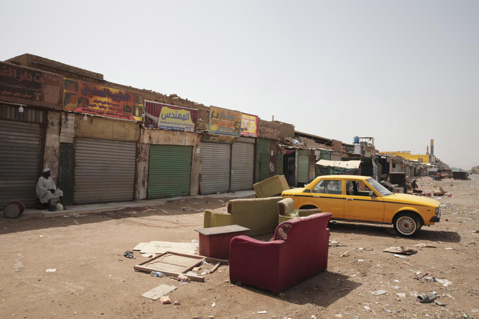 A man sits by shuttered shops in Khartoum, Sudan, Monday, April 17, 2023. Sudan's embattled capital has awoken to a third day of heavy fighting between the army and a powerful rival force for control of the country. Airstrikes and shelling intensified on Monday in parts of Khartoum and the adjoining city of Omdurman. (AP Photo/Marwan Ali)