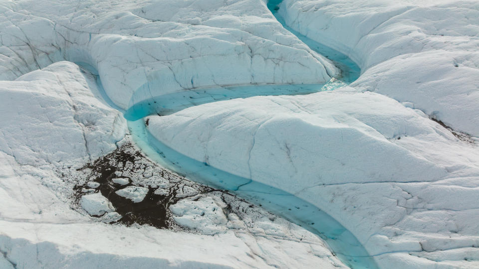 an ice sheet with rivers of water running in between cracks