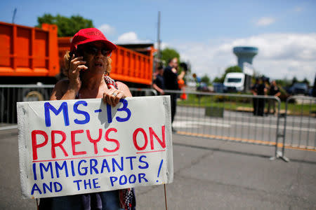 U.S. president Trump supporter holds a banner against MS-13 before a forum about Central American-based Mara Salvatrucha (MS-13) gang organization at the Morrelly Homeland Security Center in Bethpage, New York, U.S., May 23, 2018. REUTERS/Eduardo Munoz