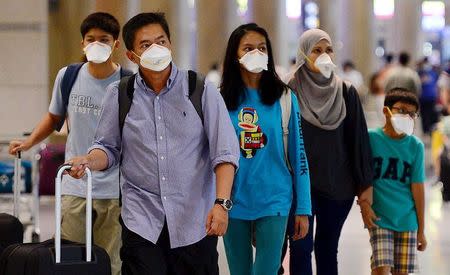 Tourists wearing masks to prevent themselves from contracting Middle East Respiratory Syndrome (MERS) arrive at the Incheon International Airport in Incheon, South Korea, June 7, 2015. REUTERS/Park Ji-hye/News1
