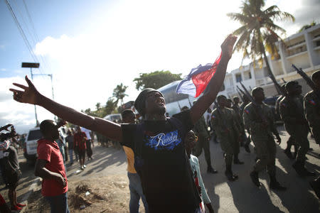 A man gestures as members of the Haitian Armed Forces (FAD'H) parade in the streets of Cap-Haitien, Haiti, November 18, 2017. REUTERS/Andres Martinez Casares