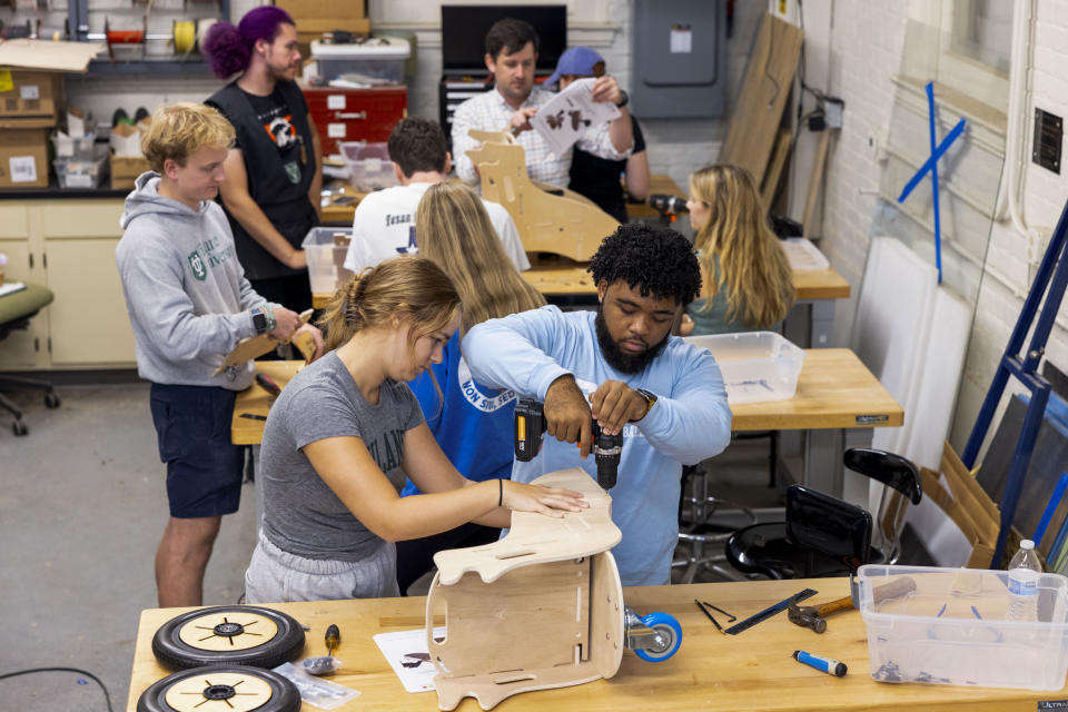 This photo released by Tulane University shows Tulane biomedical engineering students building specially designed mobility chairs for children at the MakerSpace workshop at the university Sunday, Sept. 24, 2023. The students are making the second batch of mobility chairs for toddlers, that will eventually go to pediatric patients at Children's Hospital. Wheelchairs are expensive, and insurance won't cover the cost for children unless the child proves they can operate it independently. (Sabree Hill/Tulane University via AP)