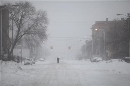 A man walks along a snow covered Cass Avenue in Detroit, Michigan January 2, 2014. REUTERS/Joshua Lott