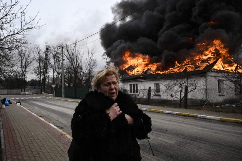 TOPSHOT - A woman reacts as she stands in front of a house burning after being shelled in the city of Irpin, outside Kyiv, on March 4, 2022. - More than 1.2 million people have fled Ukraine into neighbouring countries since Russia launched its full-scale invasion on February 24, United Nations figures showed on March 4, 2022. (Photo by Aris Messinis / AFP) (Photo by ARIS MESSINIS/AFP via Getty Images)