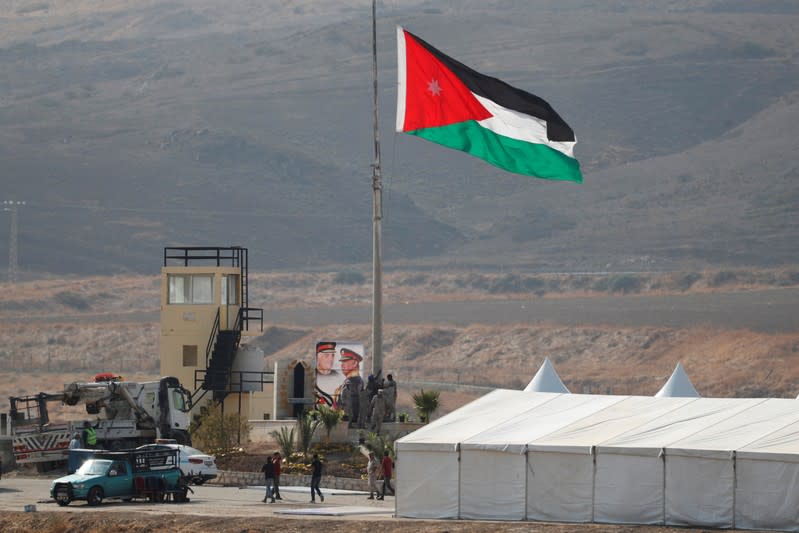 A Jordanian national flag is lifted near a tent at the "Island of Peace" in an area known as Naharayim in Hebrew and Baquora in Arabic, on the Jordanian side of the border with Israel, as seen from the Israeli side