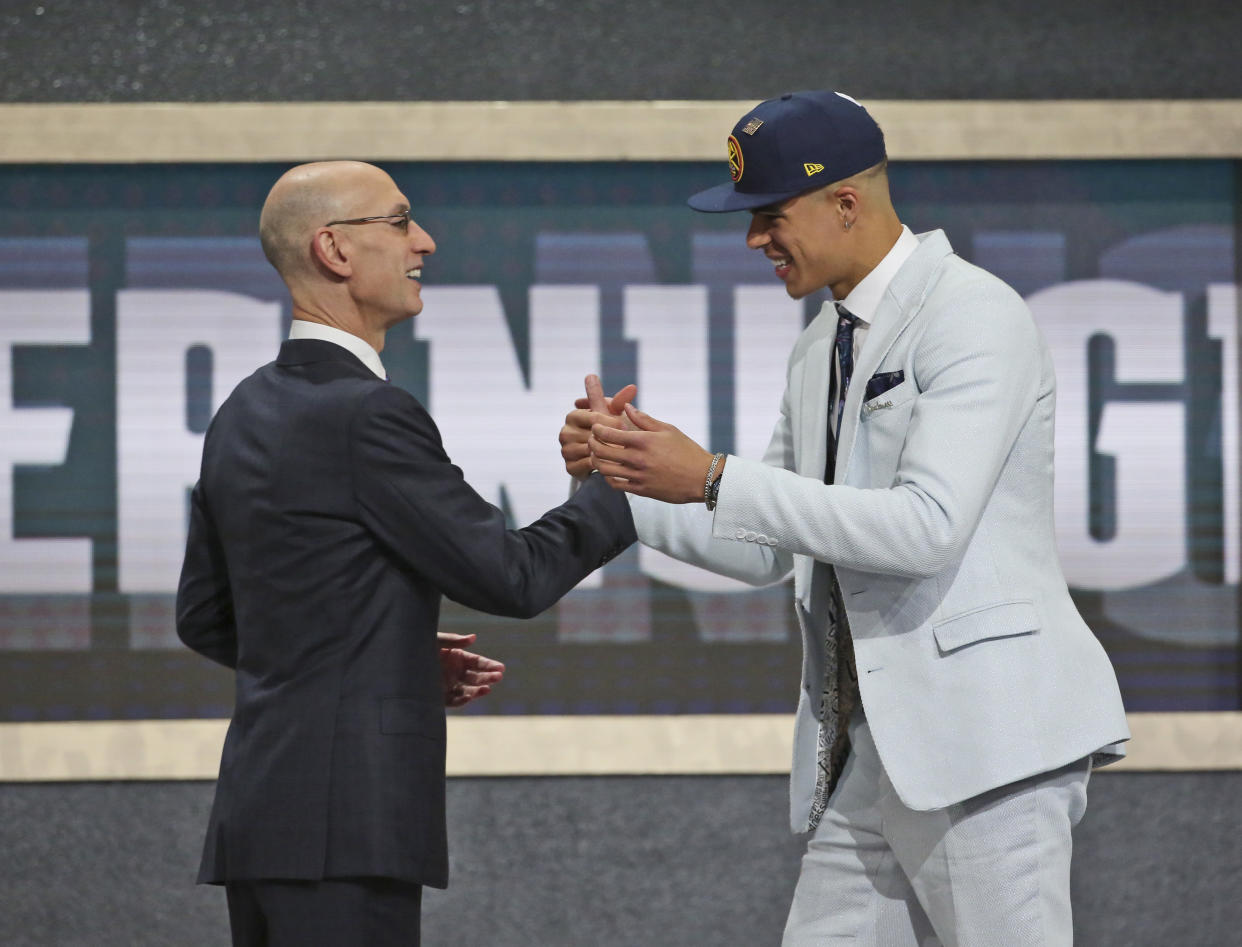 Michael Porter Jr. of Missouri, right, poses with NBA Commissioner Adam Silver after he was picked 14th overall by the Denver Nuggets during the first round of the NBA basketball draft in New York, Thursday, June 21, 2018.