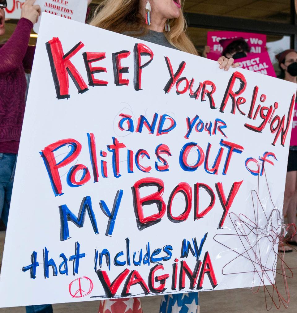 Protesters carry signs and listen to speakers as they demonstrate in front of the Paul G. Rogers Federal Building and U.S. Courthouse on May 3, 2022, in West Palm Beach, Florida. A draft opinion suggests the U.S. Supreme Court could be poised to overturn the landmark 1973 Roe v. Wade case that legalized abortion nationwide.