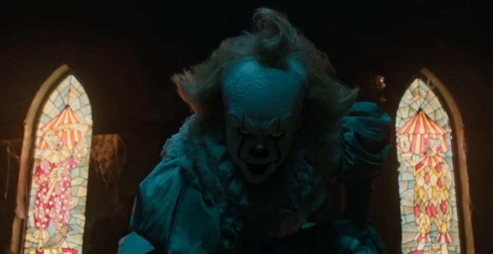 Pennywise crouching in a dark room in "It" (2017)