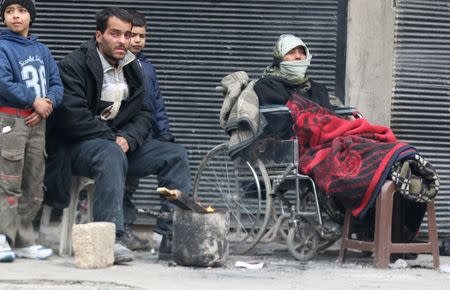 People warm themselves around a fire while waiting to be evacuated from a rebel-held sector of eastern Aleppo, Syria December 17, 2016. REUTERS/Abdalrhman Ismail