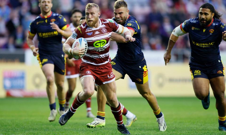 <span>Luke Thompson powers his way to Wigan’s first try in their victory against Catalans Dragons.</span><span>Photograph: Richard Sellers/PA</span>