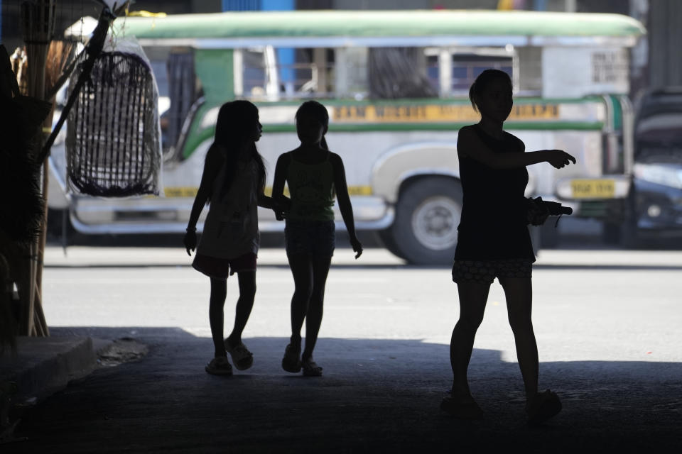 People walk under a shade during a hot day in Manila, Philippines on Monday, April 29, 2024. Millions of students in all public schools across the Philippines were ordered to stay home Monday after authorities cancelled in-person classes for two days as an emergency step due to the scorching heat and a public transport strike. (AP Photo/Aaron Favila)