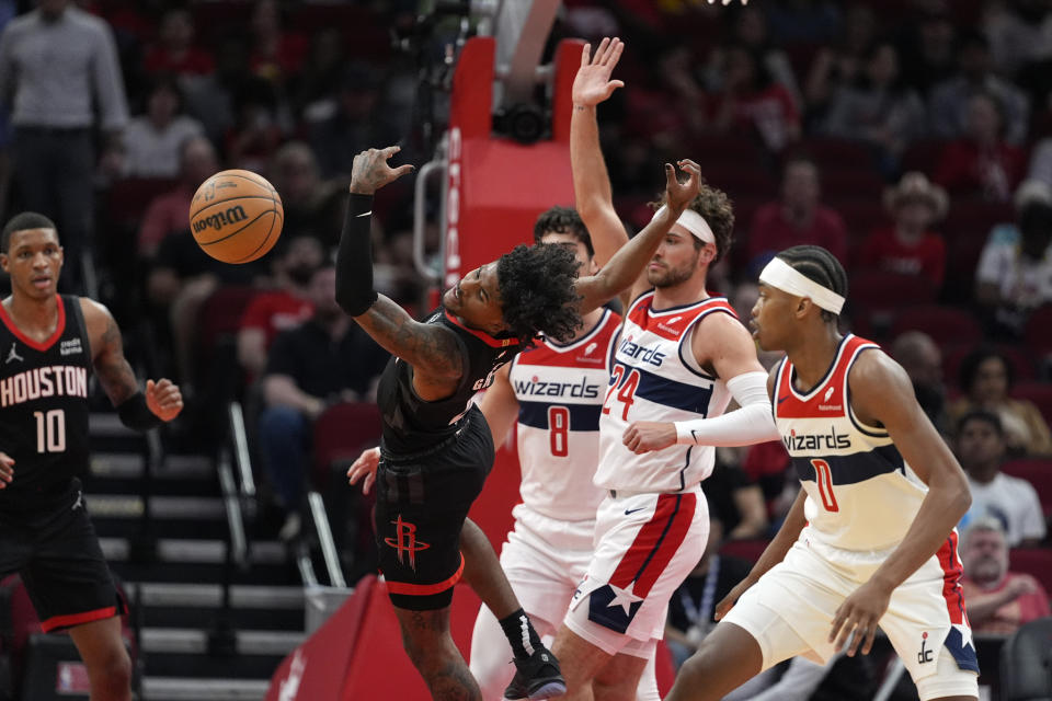 Houston Rockets' Jalen Green, left, loses the ball as Washington Wizards' Bilal Coulibaly (0) and Corey Kispert (24) defend during the first half of an NBA basketball game Thursday, March 14, 2024, in Houston. (AP Photo/David J. Phillip)